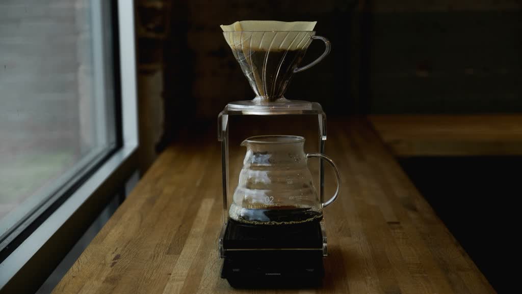 A V60 dripper on a scale beside a sunny window